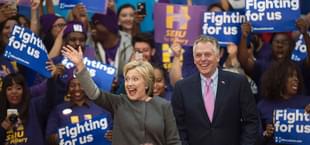 Democratic presidential hopeful Hillary Clinton waves to the crowd beside Virginia Governor Terry McAuliffe during a campaign rally February 29, 2016 at George Mason University in Fairfax, Virginia (Photo credit: PAUL J. RICHARDS/AFP/Getty Images)